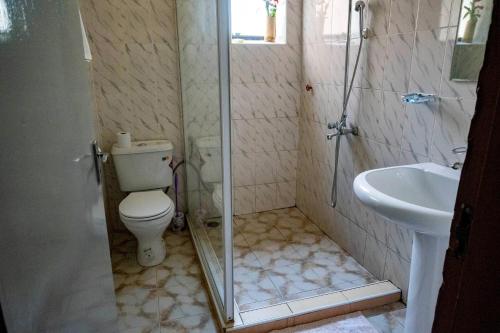 a bathroom with a toilet and a sink at Acacia Hotel Mbarara in Mbarara
