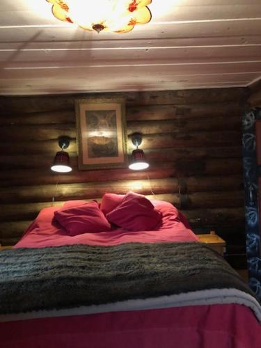 a bedroom with a bed with red sheets and two lights at Vemdalsskalsgården in Vemdalen