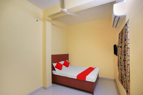 - une chambre avec un lit doté d'oreillers rouges et blancs dans l'établissement OYO Flagship Hotel Sai Saugat, à Bilāspur