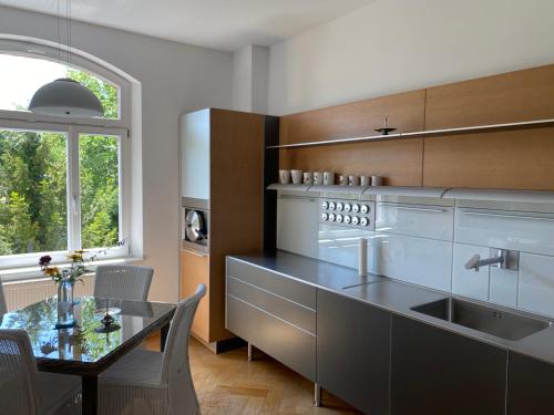 cocina con fogones, mesa y ventana en Helsinki Apartment 2, en Erfurt