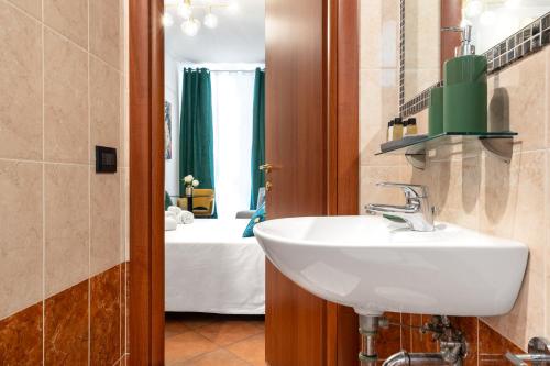 a bathroom with a sink and a room with a bed at Colosseo Relais in Rome