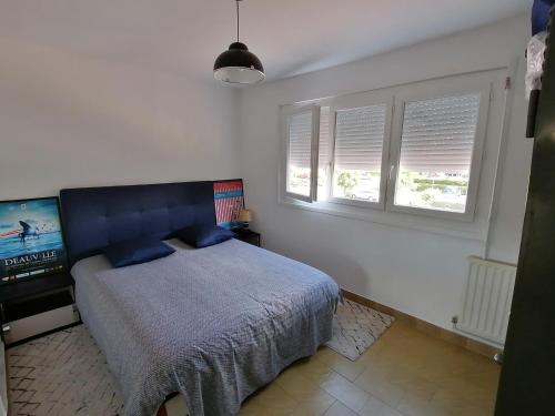 a bedroom with a bed and a flat screen tv at appartement 50 m2 vue mer in Villers-sur-Mer