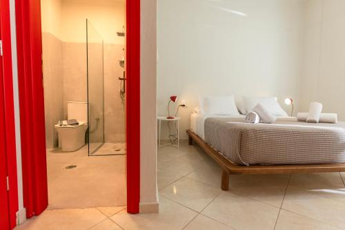 a bedroom with a large bed and a bathroom at Mondrian Guest House in Skiathos
