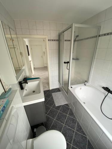 a bathroom with a shower and a tub and a sink at FeWo Gladbeck in Gladbeck