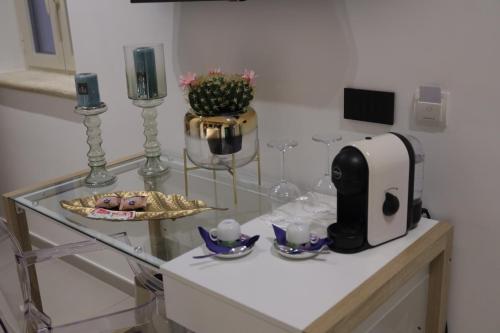 a glass table with a toaster and glasses on it at Relais Dea Degli Ulivi in Agrigento