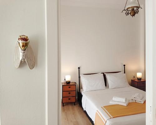 a white bedroom with a bed and two night stands at nona's in Thessaloniki