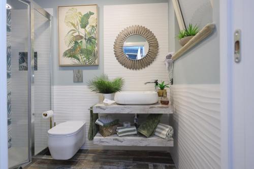 a bathroom with a sink and a toilet and a mirror at Relais Dea Degli Ulivi in Agrigento