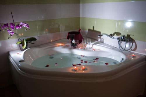 a bathroom with a tub with candles in it at Hotel Donna Carmela Sede Unica a Sciacca in Sciacca