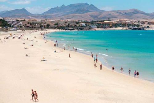 un gruppo di persone su una spiaggia con l'oceano di Casa Fuerteventura a Costa Calma