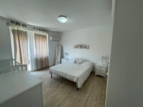 - une chambre blanche avec un lit et une fenêtre dans l'établissement Casa Linda, à Cupello