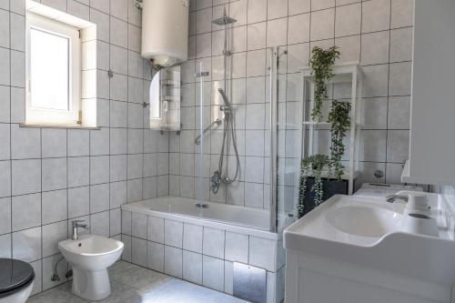 a bathroom with a tub and a toilet and a sink at Villa Akulica in Jakišnica