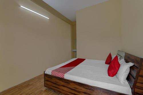 a bedroom with a bed with red pillows at OYO Flagship Prachi Guest House in Gorakhpur