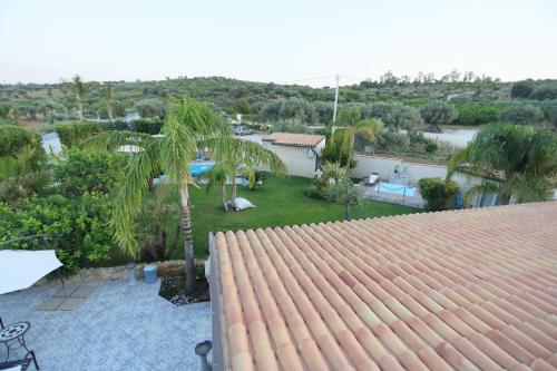 a view of a backyard with a pool and palm trees at Relais Dea Degli Ulivi in Agrigento