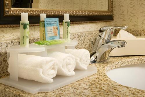 - un lavabo dans la salle de bains avec des serviettes sur une étagère à côté d'un lavabo dans l'établissement Holiday Inn Express & Suites by IHG Chambersburg, an IHG Hotel, à Chambersburg