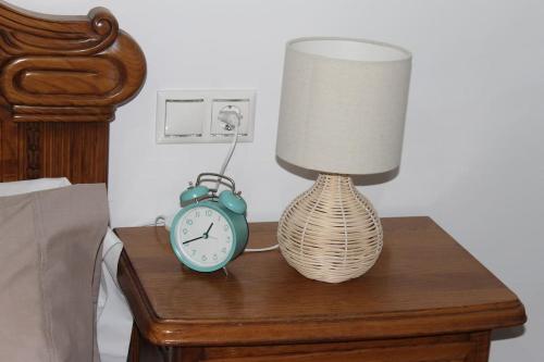 una lámpara y un reloj despertador sobre una mesa en Apartamentos Camino Inglés, en Ordes