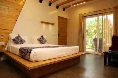 a bedroom with a large bed with a window at DESI THATH RESORT in Alwar