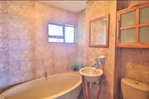 a bathroom with a tub and a sink at Holiday house on the beach in Kingsborough