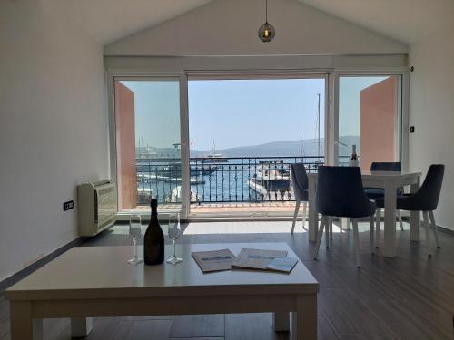 ein Wohnzimmer mit einem Tisch und einer Flasche Wein in der Unterkunft Opera apartments in Tivat