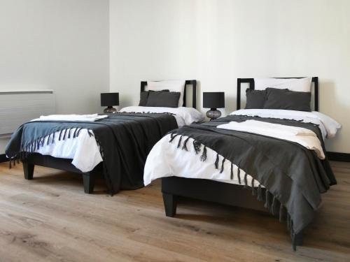 2 camas en una habitación con suelo de madera en Appartement au centre ville en Lourdes