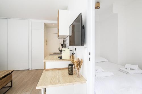 une chambre avec un lit et un bureau avec une télévision dans l'établissement Pick A Flat's Apartment in Place des Ternes - Boulevard Gouvion-Saint-Cyr, à Paris