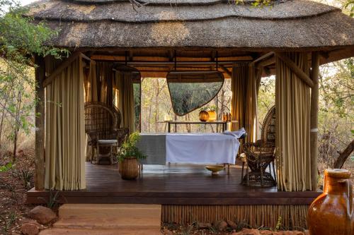 a gazebo with a table on a wooden deck at Molori Safari in Derdepoort