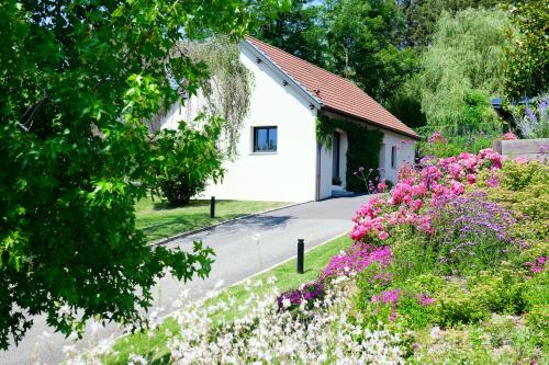 a small white house with flowers in front of it at Le Clos des Ecureuils in Saint-Héand