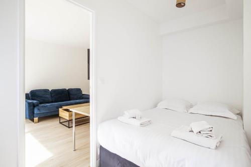 une chambre avec un lit et un canapé bleu dans l'établissement Pick A Flat's Apartment in Place des Ternes - Boulevard Gouvion-Saint-Cyr, à Paris
