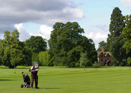 a man playing golf with a stroller in a park at Walwyn Court Barns in Ledbury