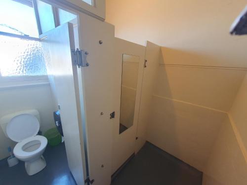 a small bathroom with a toilet and a window at Pier Hotel in Port Lincoln