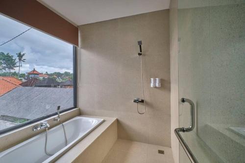 uma casa de banho com uma banheira e uma janela em Lavilla B1 New-3BR Pool Villa 15 Mins from Ubud Centre em Ubud