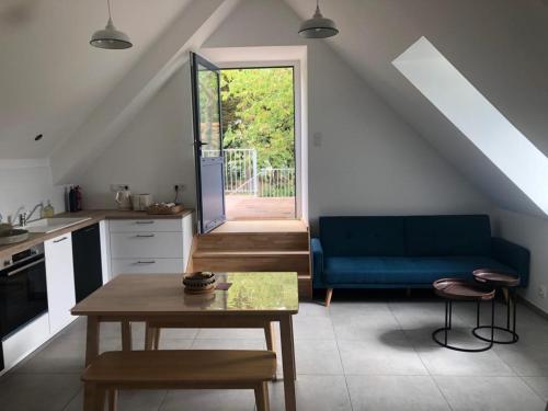 a living room with a blue couch and a table at Les écolodges Sous Le Phare in Louannec