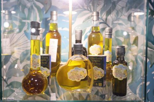 a group of bottles of alcohol sitting on a shelf at Relais Dea Degli Ulivi in Agrigento