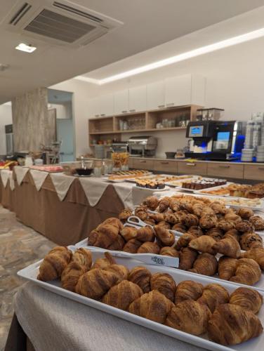 a table with several trays of food on display in a kitchen at Hotel Solemare - Frontemare - 3 Stelle Superior in Lido di Jesolo