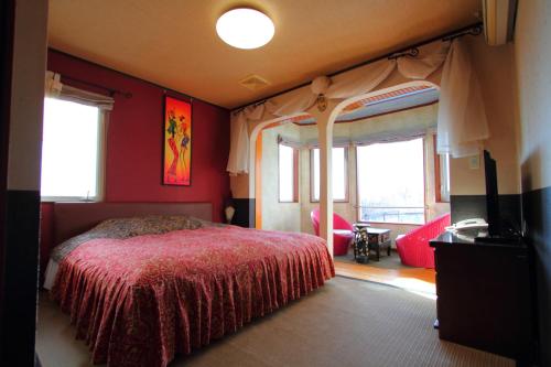 a bedroom with a bed with red walls and windows at Scotch Court in Nasu