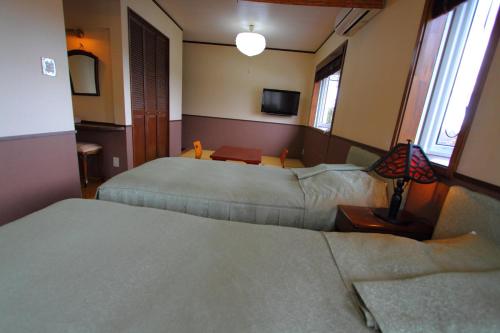 a hotel room with two beds and a couch at Scotch Court in Nasu