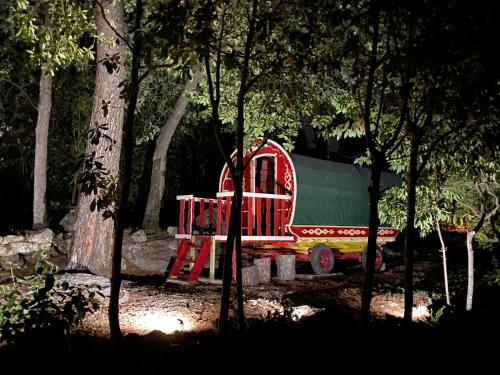 Un train de jouets est assis dans une forêt dans l'établissement Les roulottes de Bayama - logement insolite avec jacuzzi, à Mougins