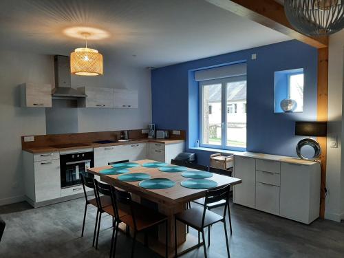 une cuisine avec une table, des chaises et un mur bleu dans l'établissement Domaine de Feix, à Combressol
