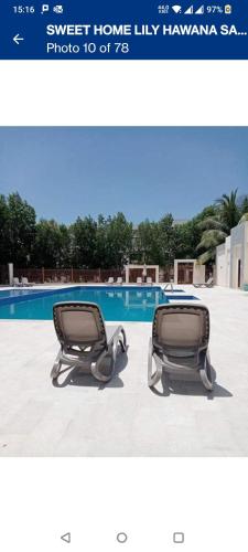 a picture of two chairs in front of a swimming pool at Hawana Salalah Laguna Studio in Salalah