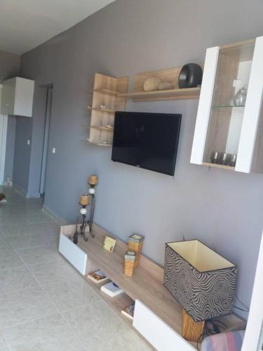 ein Wohnzimmer mit einem Flachbild-TV an der Wand in der Unterkunft Alex apartments relax in Agia Marina Mikrolimanou