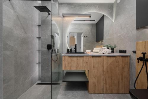 ein Bad mit einem Waschbecken und einer Dusche in der Unterkunft Exclusive Apartment with Balcony & Parking Wrocław by Renters Prestige in Breslau