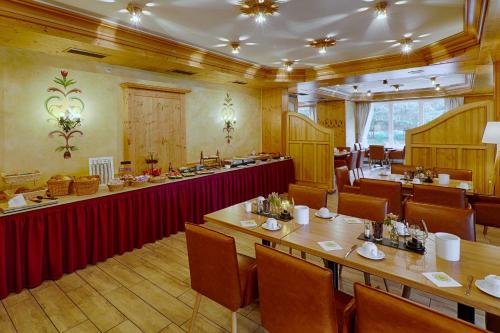 a restaurant with a long table and chairs in it at Hotel und Berggasthof Tanzbuche in Friedrichroda