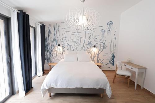 1 dormitorio con cama y papel pintado azul y blanco en Pierres Blanches Guérande - Maison d'hôtes en Guérande