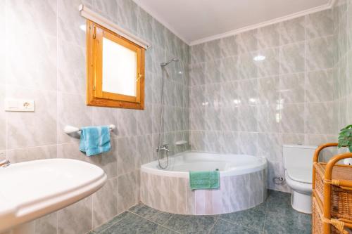a bathroom with a tub and a toilet and a sink at Villa Rafael in Cumbre del Sol