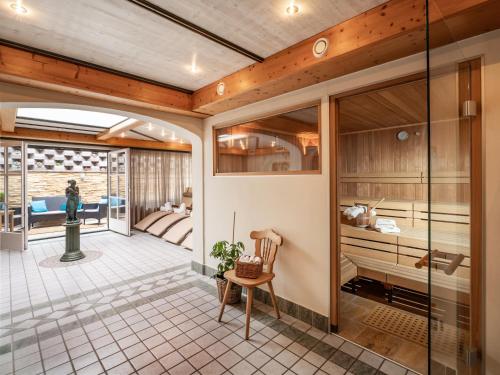 a kitchen with glass doors and a table and a chair at Alpen Glück Hotel Villa Lisa garni in Kirchberg in Tirol