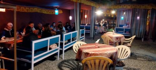 grupa ludzi siedzących przy stolikach w restauracji w obiekcie Mentokling Guest House and Garden Restaurant w mieście Leh