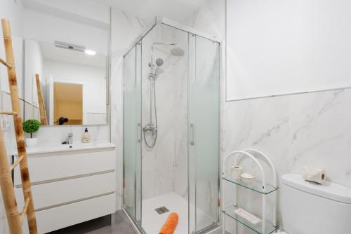 baño blanco con ducha y lavamanos en Casa Beramendi, en Torremolinos