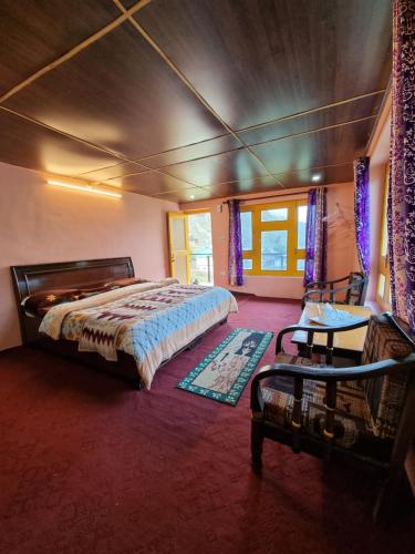a bedroom with a bed and a table in it at LAP Stays - Wanderer's Nest in Chitkal