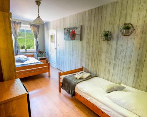 1 dormitorio con 2 camas y ventana en Zajazd Avena en Krokowa