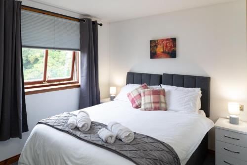 a bedroom with a bed with towels on it at Bothwell Court Apartments in Dunfermline