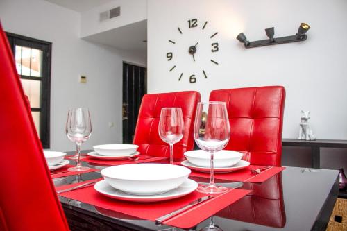 una mesa con sillas rojas y un reloj en la pared en Second line Puerto Banús top floor, en Marbella